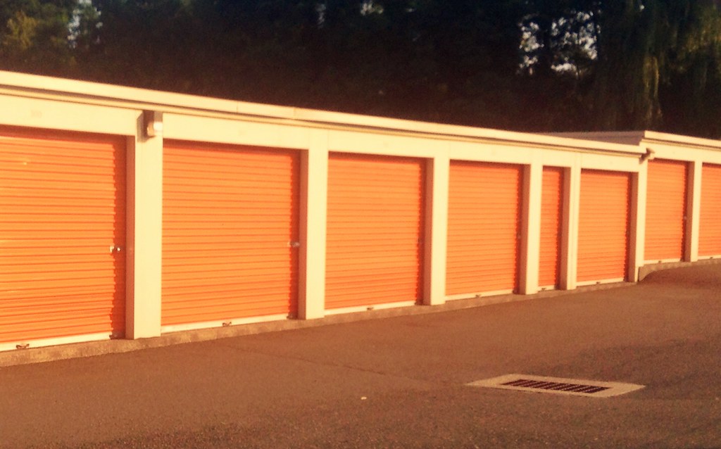 A row of drive-up self storage units with roll-up doors